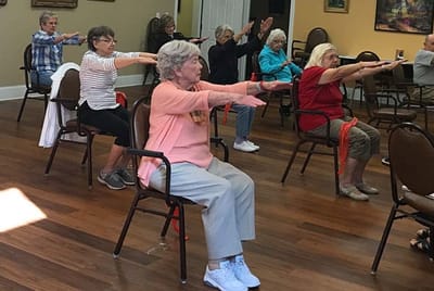 Seniors participating in an exercise class in a common area