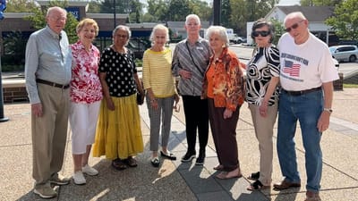 Group of smiling residents standing outside the facility
