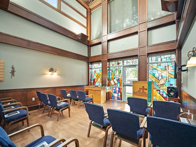 Interior view of a serene activity room with stained glass windows