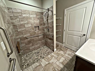 Accessible bathroom with grab bars and tiled shower