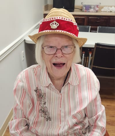 Resident smiling in a festive hat during an activity