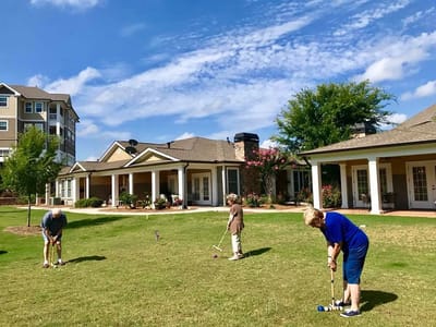 Residents enjoying outdoor activities in a landscaped area