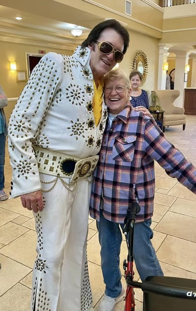 Resident happily posing with an Elvis impersonator