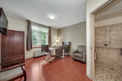 Resident room featuring a bed, seating area, and window