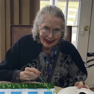 Resident painting in a bright activity room
