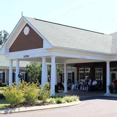 Exterior view of Someroak Senior Living with residents relaxing