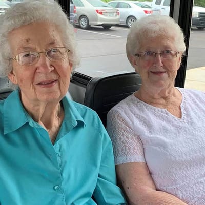 Two cheerful senior women smiling together