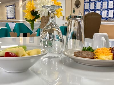 A table setting with meals and fresh fruit in a dining area