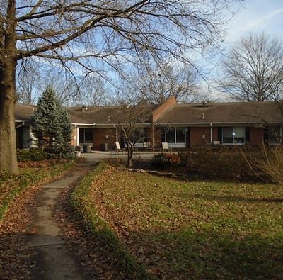 Pathway leading to a senior living exterior with gardens