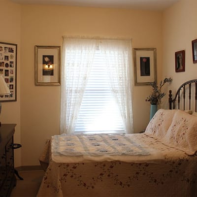 Cozy bedroom setup with floral quilt and window light