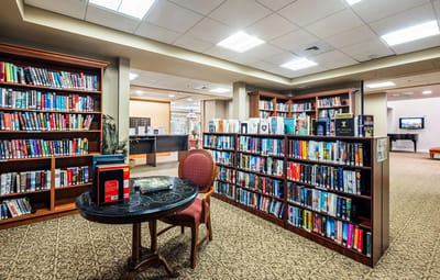 Interior view of a library with bookshelves and a reading table
