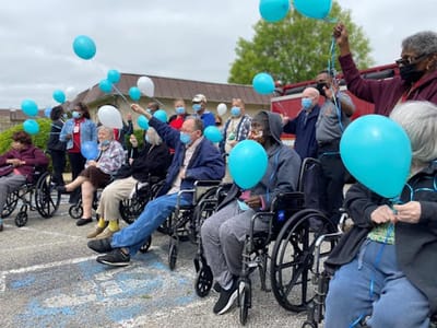 Residents celebrating outdoors with balloons