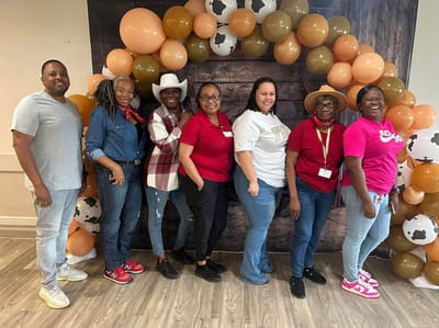 Staff members standing together in a decorated common area