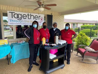 Staff members serving refreshments at an outdoor event
