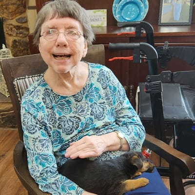 Resident smiling while petting a dog