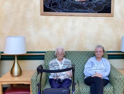 Two residents sitting in a common area on a couch