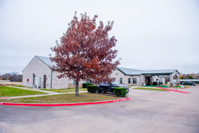 Exterior view of the assisted living facility with a tree
