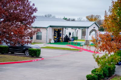 Building entrance with decorated path and vehicle