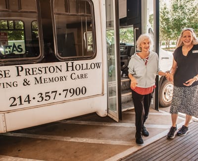 Resident exiting a facility transport vehicle with staff