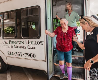Residents exiting a transport van at the facility