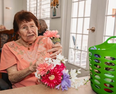Resident arranging flowers in an activity room