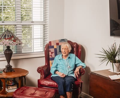 Elderly woman sitting in a chair in a cozy room