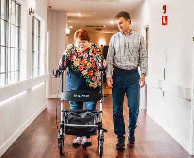 Staff assisting a resident in a hallway