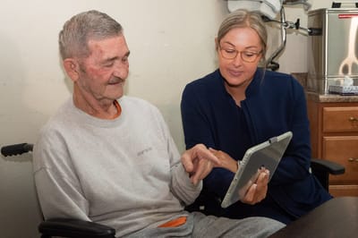 Resident and staff member engaged with a tablet