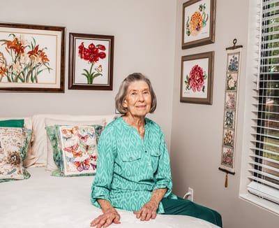 Resident sitting on a bed in a cozy room