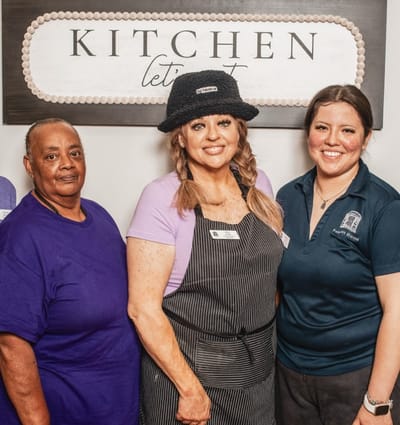 Staff members posing together in a kitchen area
