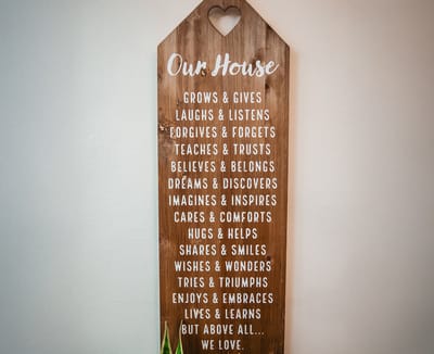 A wooden sign with positive phrases about community and support