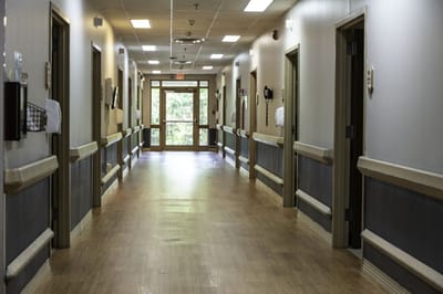 A hallway leading to the entrance of a senior care facility