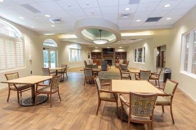 Common area with tables and chairs in a bright room