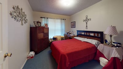 Cozy private resident room with red bedding and personal items