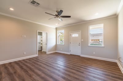 Bright and spacious interior room with a ceiling fan