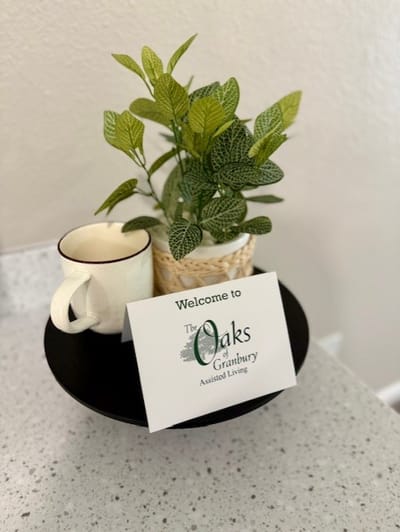 Welcome sign with decorative plant at the Oaks of Granbury