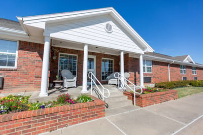 Exterior view of the facility entrance with flower beds