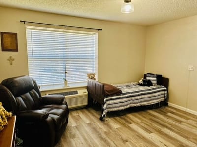 Interior view of a resident room with a bed and recliner