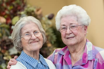 Two smiling senior women posing together