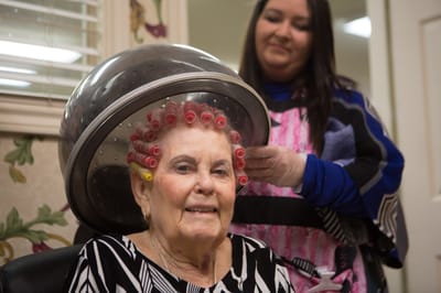 A resident receiving a salon treatment in a cozy setting