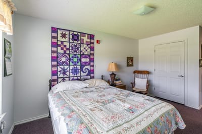 Cozy resident room with a quilt and rocking chair