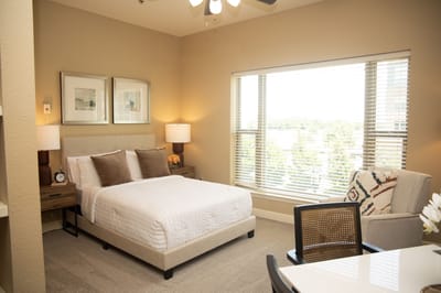 Cozy, well-lit resident room with a bed and seating area