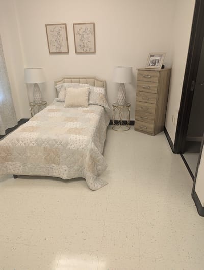 Well-decorated private resident room with a bed