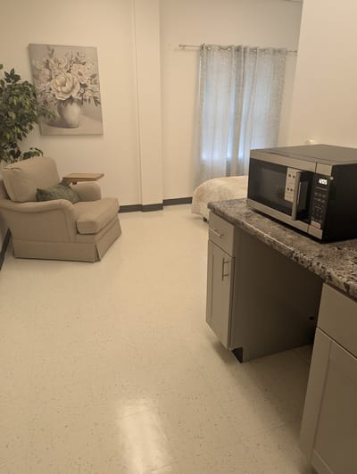 Cozy resident room with a chair and microwave