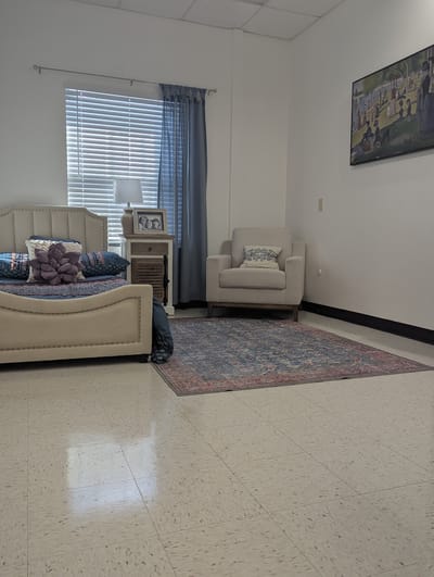 Cozy resident room setup with a bed and chair