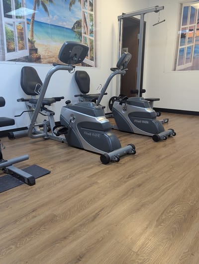 Exercise equipment in a bright room with beach mural