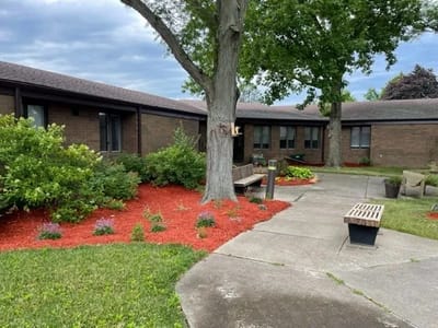 Outdoor view of The Elms facility entrance and landscaping
