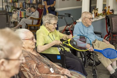 Residents participating in a tennis activity inside the facility