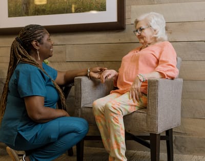 Caregiver interacting with a senior resident in a cozy space