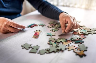 A resident assembling a jigsaw puzzle at a table